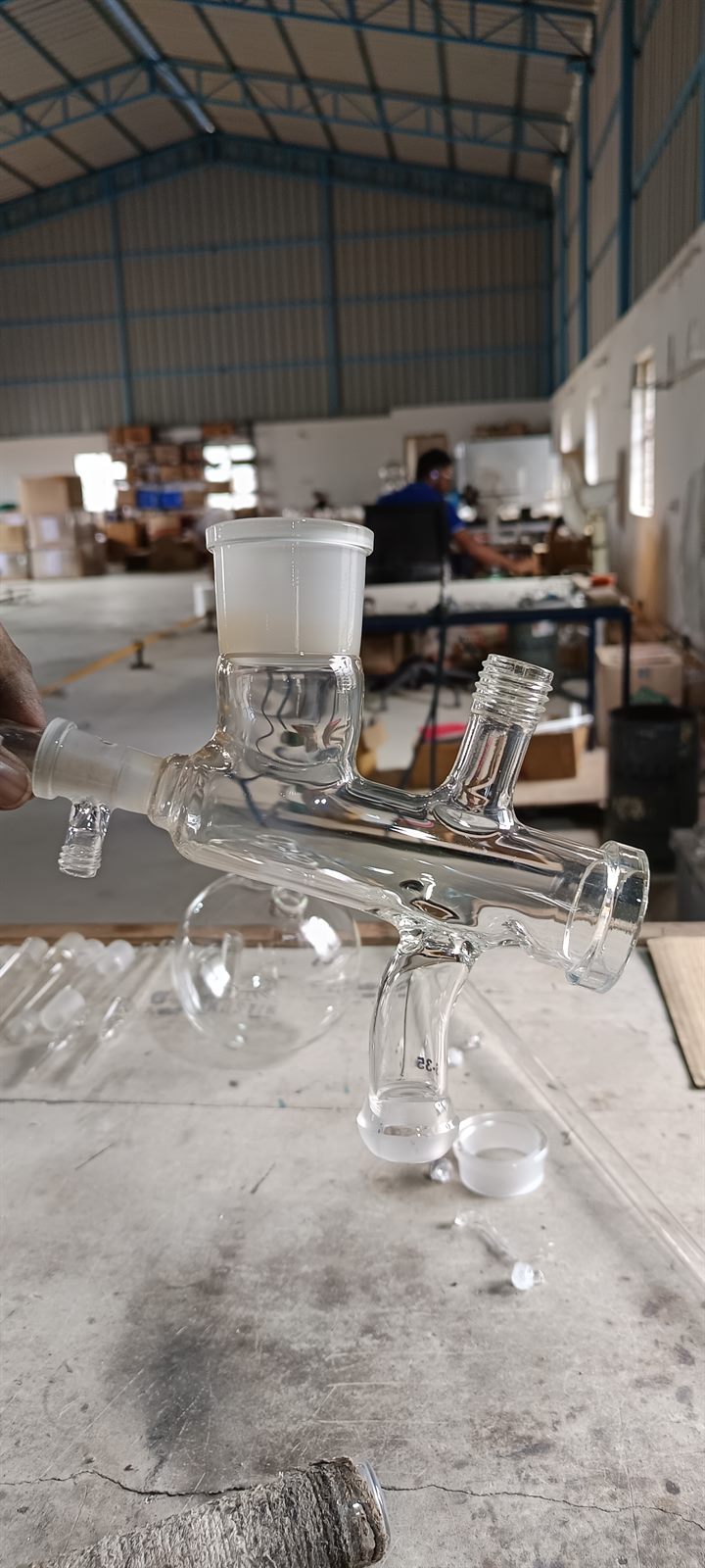 Laboratory glass assembly with workshop team in background